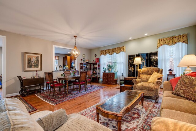 living room featuring an inviting chandelier, recessed lighting, and wood finished floors