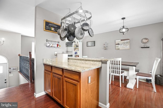 10708 Live Oak Ct, Fredericksburg, VA 22407 - kitchen with dark wood-type flooring, brown cabinetry, light stone counters, decorative light fixtures, and a peninsula