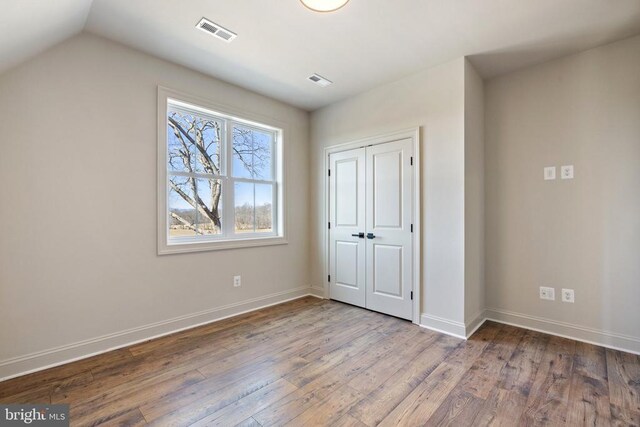 7039 Silk, Jeffersonton, VA 22724 - unfurnished bedroom with wood finished floors, baseboards, a closet, and lofted ceiling