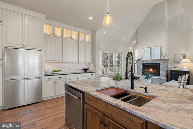 7039 Silk, Jeffersonton, VA 22724 - kitchen featuring appliances with stainless steel finishes, a sink, recessed lighting, a stone fireplace, and wood finished floors