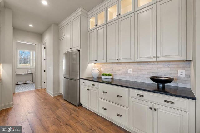 7039 Silk, Jeffersonton, VA 22724 - kitchen with freestanding refrigerator, dark countertops, decorative backsplash, white cabinetry, and baseboards