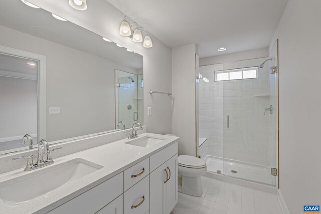 full bathroom featuring a sink, double vanity, toilet, and a stall shower