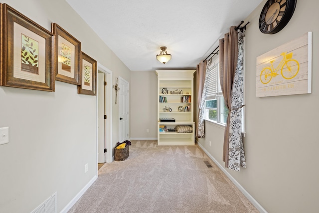 corridor with light colored carpet and baseboards