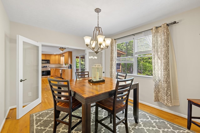 dining space featuring plenty of natural light, a chandelier, and light wood-type flooring