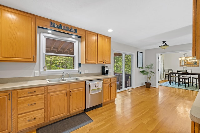 kitchen featuring stainless steel dishwasher, a sink, light countertops, healthy amount of natural light, and recessed lighting