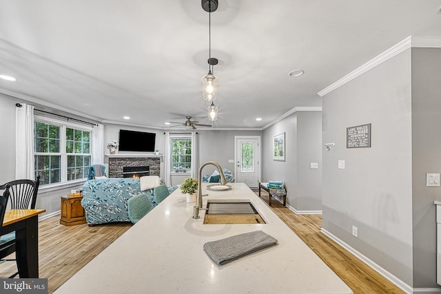 343 Aspen Hill Rd, Mineral, VA 23117 - kitchen with ornamental molding, a sink, a fireplace, light wood-style floors, and baseboards