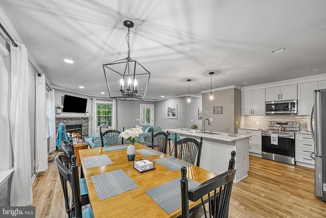 343 Aspen Hill Rd, Mineral, VA 23117 - dining space featuring recessed lighting, a stone fireplace, ornamental molding, light wood-type flooring, and a chandelier