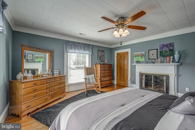 202 Cutler Ave, Louisa, VA 23093 - bedroom with crown molding, wood finished floors, a glass covered fireplace, baseboards, and ceiling fan
