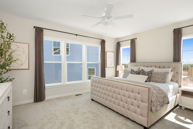bedroom with light colored carpet, a ceiling fan, baseboards, and visible vents