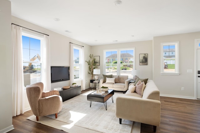 living area featuring baseboards and dark wood finished floors