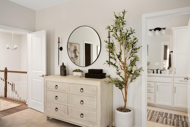 room details with a sink, an inviting chandelier, and wood finished floors