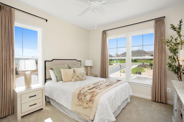 bedroom with baseboards, a ceiling fan, and light colored carpet