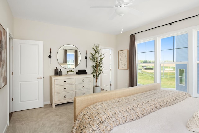 bedroom featuring baseboards, ceiling fan, and light colored carpet
