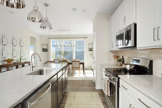 kitchen featuring decorative backsplash, dark wood-style flooring, visible vents, a sink, and stainless steel appliances