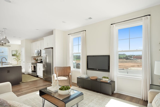 living area with light wood-style floors and baseboards