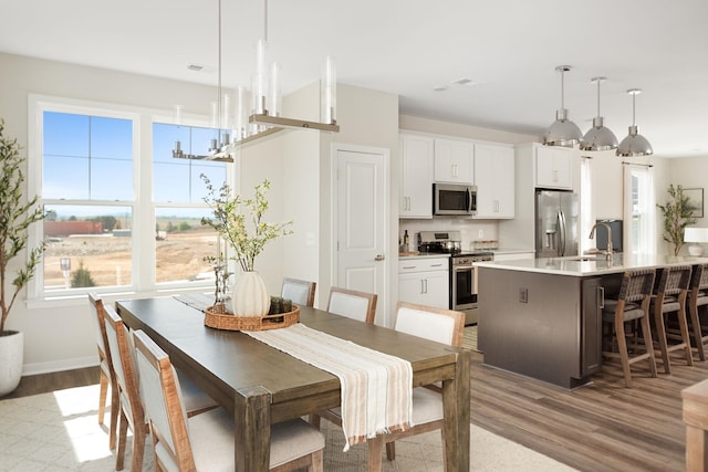 dining area featuring visible vents, baseboards, and wood finished floors