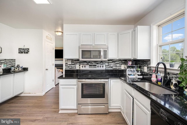 7504 Heathrow Dr, Fredericksburg, VA 22407 - kitchen with appliances with stainless steel finishes, a sink, backsplash, white cabinets, and light wood-style floors