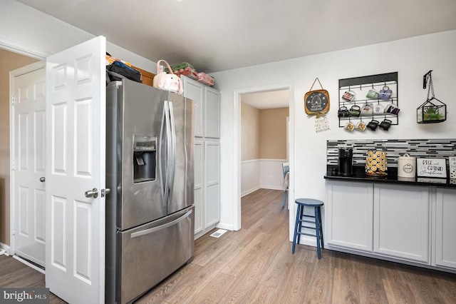 7504 Heathrow Dr, Fredericksburg, VA 22407 - kitchen with stainless steel refrigerator with ice dispenser, wood finished floors, tasteful backsplash, and dark countertops