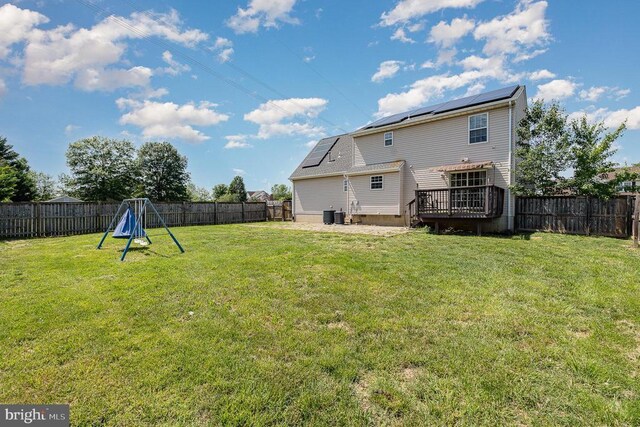 7504 Heathrow Dr, Fredericksburg, VA 22407 - rear view of house with a wooden deck, solar panels, and a fenced backyard