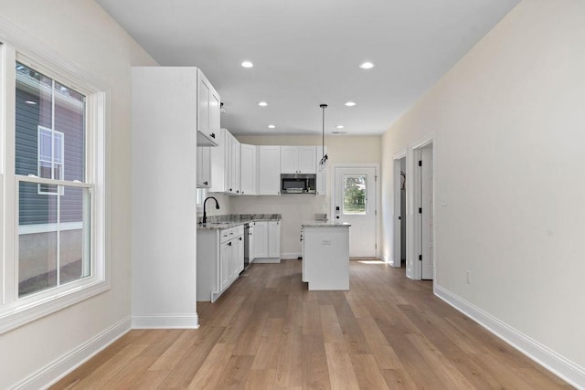 1019 Frye St, Waynesboro, VA 22980 - kitchen with stainless steel microwave, light wood-type flooring, white cabinets, a kitchen island, and recessed lighting