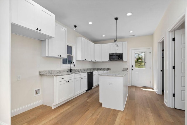 1019 Frye St, Waynesboro, VA 22980 - kitchen with stainless steel microwave, dishwasher, light wood-style flooring, white cabinetry, and light stone countertops