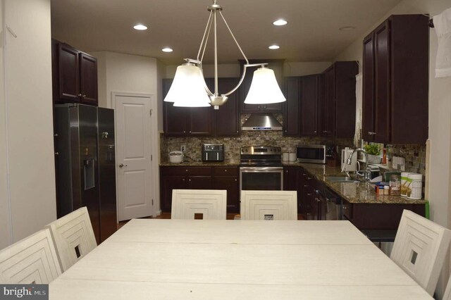 kitchen featuring stainless steel appliances, a sink, under cabinet range hood, decorative backsplash, and recessed lighting