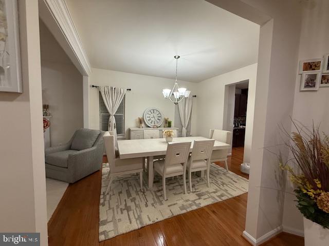 dining space featuring wood finished floors and a chandelier