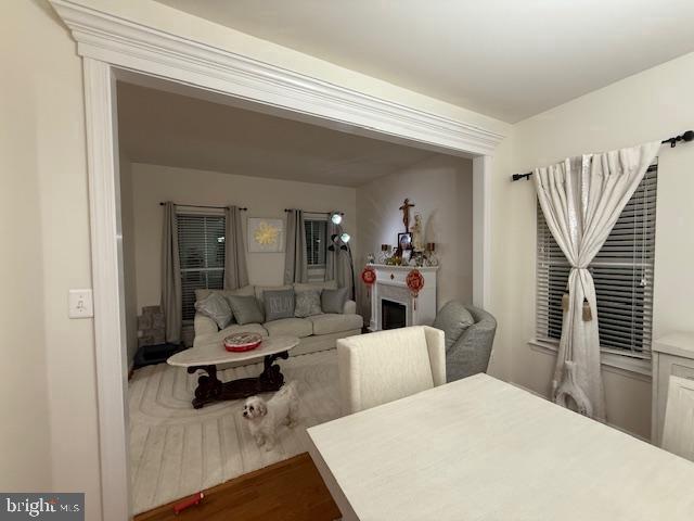 dining space with wood finished floors and a fireplace