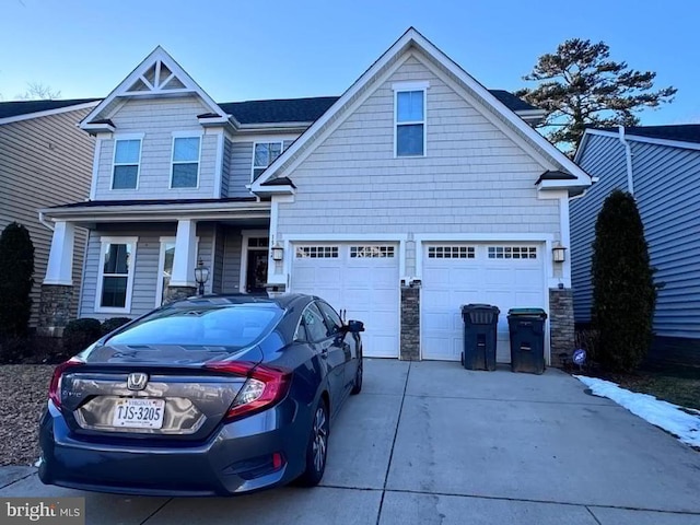 view of front of property featuring stone siding, driveway, and a garage