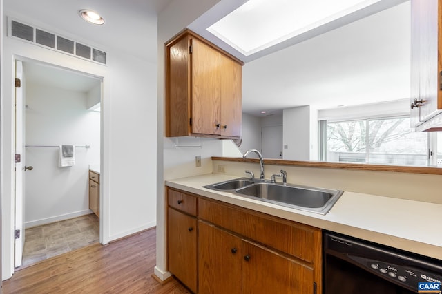 kitchen featuring a sink, light countertops, black dishwasher, and visible vents