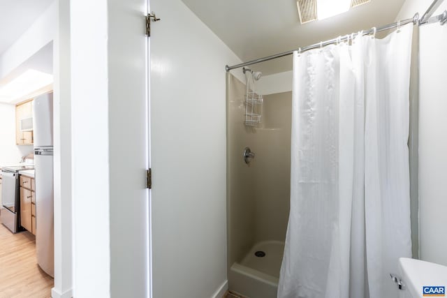 bathroom with vanity, a shower stall, and wood finished floors