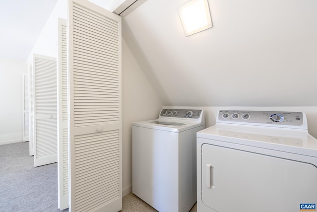 clothes washing area featuring separate washer and dryer, laundry area, and light carpet