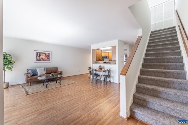 stairway featuring baseboards and wood finished floors
