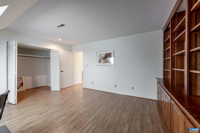unfurnished bedroom featuring baseboards, light wood-style floors, a closet, and visible vents