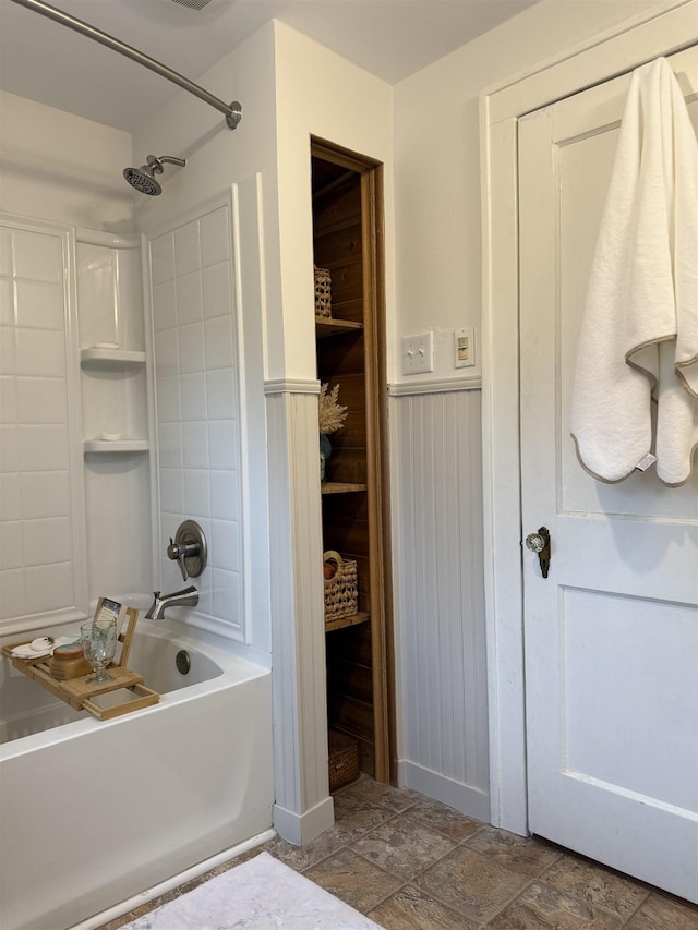 228 Hendren Ave, Staunton, VA 24401 - bathroom with tub / shower combination, a wainscoted wall, and stone finish floors