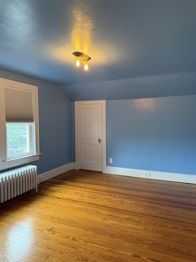 228 Hendren Ave, Staunton, VA 24401 - empty room with radiator, vaulted ceiling, baseboards, and wood finished floors