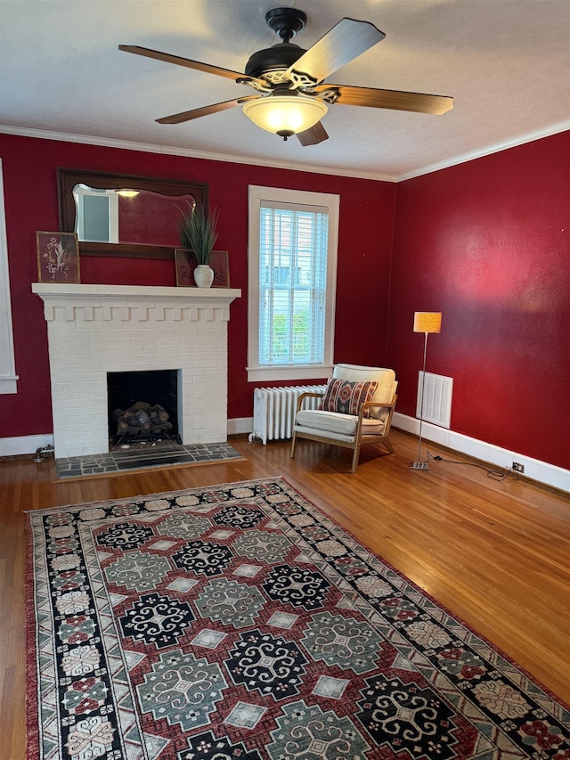 228 Hendren Ave, Staunton, VA 24401 - living area featuring radiator, wood finished floors, ceiling fan, ornamental molding, and a fireplace