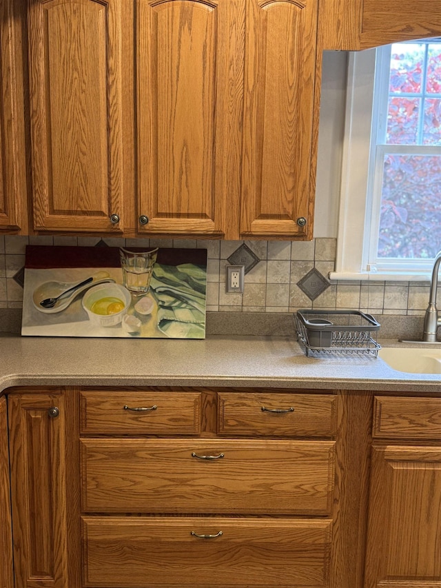 228 Hendren Ave, Staunton, VA 24401 - kitchen featuring backsplash, brown cabinetry, and a sink