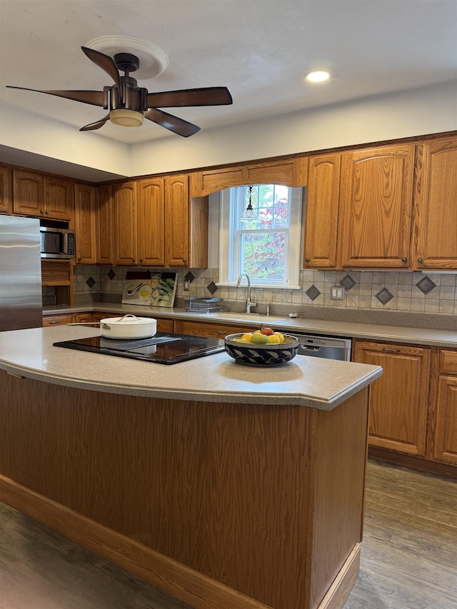 228 Hendren Ave, Staunton, VA 24401 - kitchen with a center island, a sink, brown cabinets, decorative backsplash, and stainless steel appliances