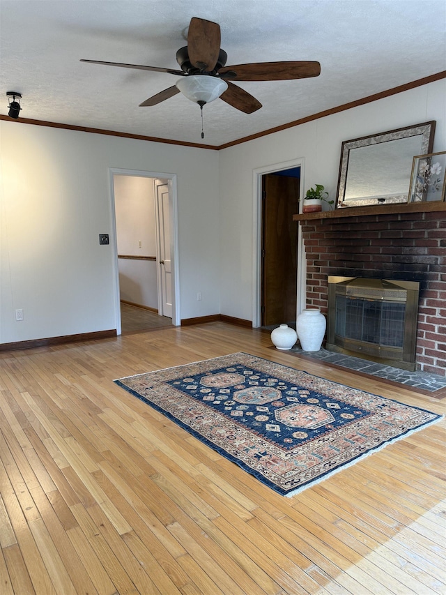 228 Hendren Ave, Staunton, VA 24401 - living area featuring wood-type flooring, baseboards, a ceiling fan, a brick fireplace, and crown molding