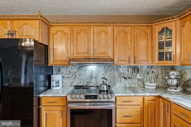 1066 Honeyville Rd, Stanley, VA 22851 - kitchen featuring stainless steel range with electric stovetop, freestanding refrigerator, under cabinet range hood, a textured ceiling, and glass insert cabinets