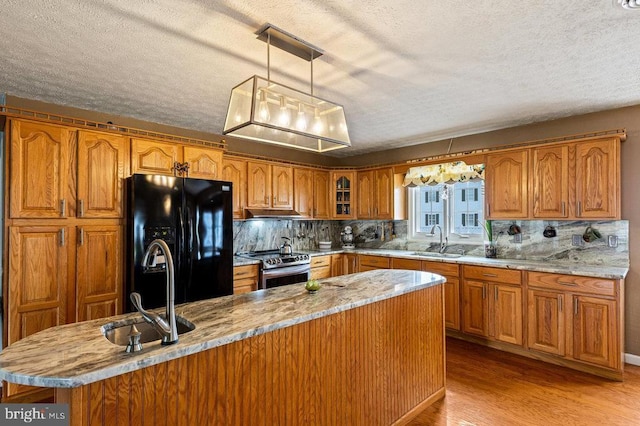 1066 Honeyville Rd, Stanley, VA 22851 - kitchen featuring black fridge, stainless steel range with electric stovetop, a sink, brown cabinets, and a textured ceiling