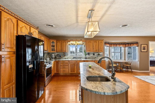 1066 Honeyville Rd, Stanley, VA 22851 - kitchen with black fridge with ice dispenser, a sink, electric range, a textured ceiling, and light wood finished floors