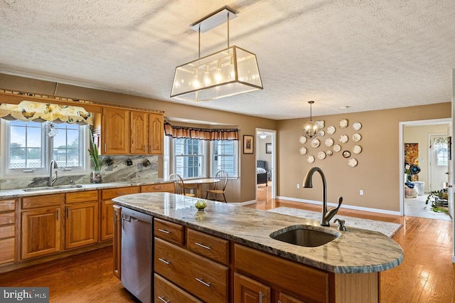 1066 Honeyville Rd, Stanley, VA 22851 - kitchen with a textured ceiling, dishwasher, a sink, wood finished floors, and brown cabinets