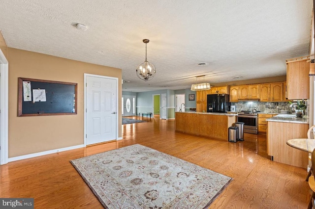 1066 Honeyville Rd, Stanley, VA 22851 - kitchen with freestanding refrigerator, a chandelier, a textured ceiling, stainless steel stove, and light wood-type flooring