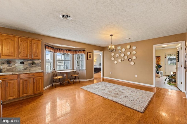 1066 Honeyville Rd, Stanley, VA 22851 - dining space with light wood-type flooring, plenty of natural light, baseboards, a textured ceiling, and a chandelier
