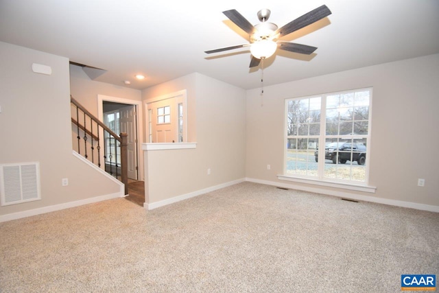 unfurnished room featuring light carpet, visible vents, stairway, and baseboards