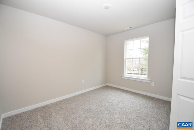 carpeted empty room featuring visible vents and baseboards