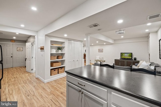  - kitchen with dark countertops, light wood-style flooring, open floor plan, recessed lighting, and gray cabinets