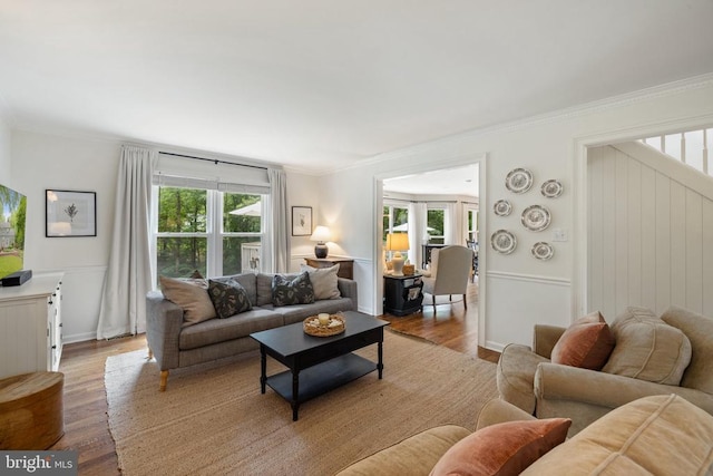  - living area featuring wood finished floors, ornamental molding, and baseboards